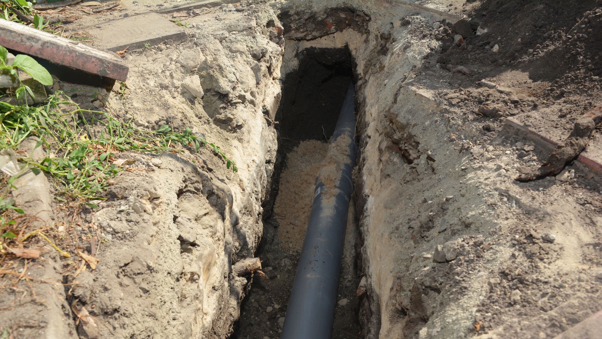 Rura kanalizacyjna układana w wykopie podczas montażu zewnętrznego przyłącza wodno-kanalizacyjnego